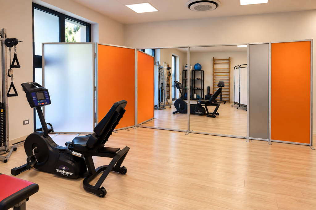 Parete divisoria autoportante con specchi bifacciali e pannelli satinati in uno studio fitness realizzata da Studio T